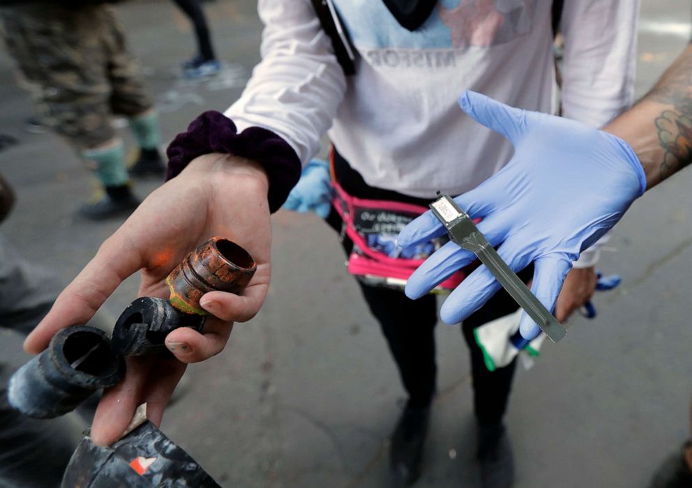 PHOTO: A person holds debris from projectiles and other devices they say were used by police during clashes with protesters, July 25, 2020, during a Black Lives Matter protest near the Seattle Police East Precinct headquarters.