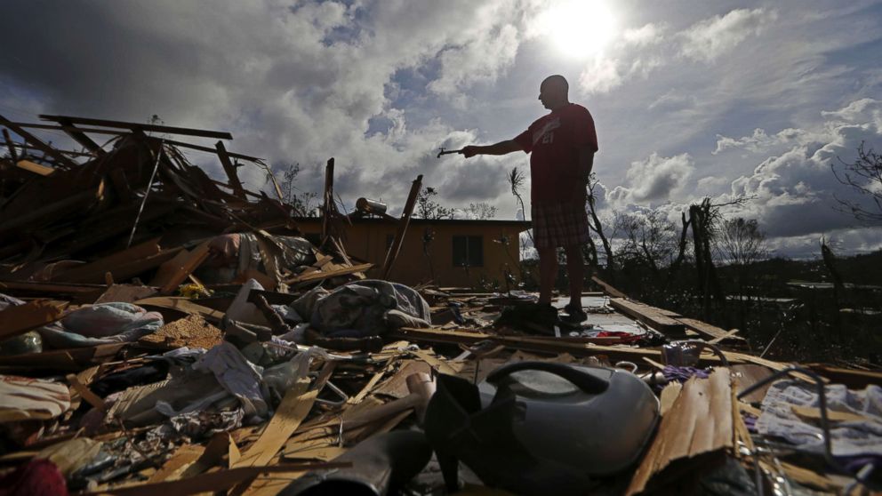 Jose Garcia Vicente holds a piece of plumbing he picked up, as he shows his destroyed home, in the aftermath of Hurricane Maria, in Aibonito, Puerto Rico, Sept. 25, 2017.
