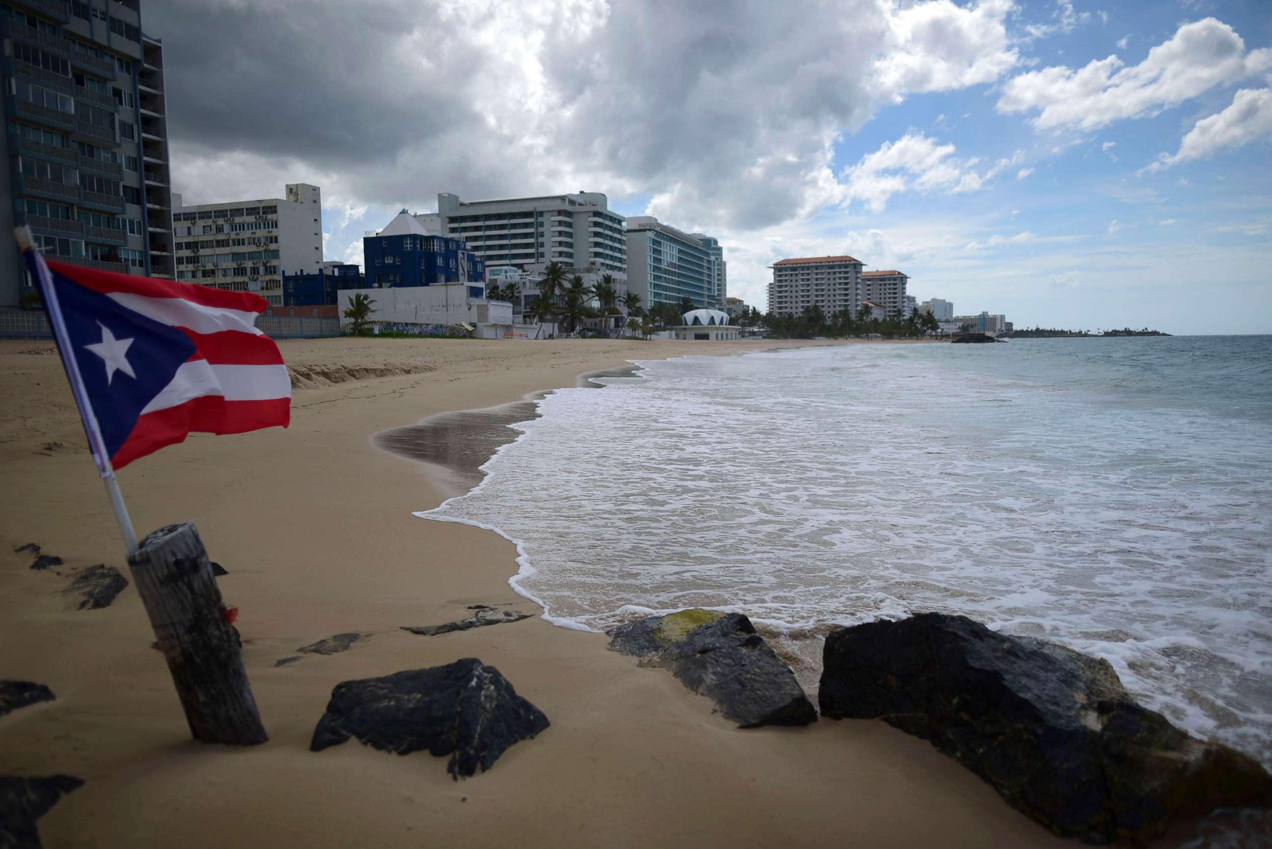 PHOTO: A Puerto Rican flag flies on an empty beach at Ocean Park, in San Juan, Puerto Rico, May 21, 2020, during the coronavirus pandemic.