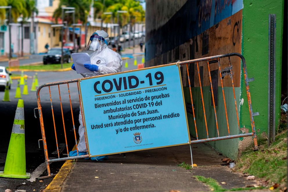 PHOTO: A medical worker stands at the entrance of a municipal COVID-19 drive-thru testing site in San Juan, Puerto Rico on March 25, 2020.