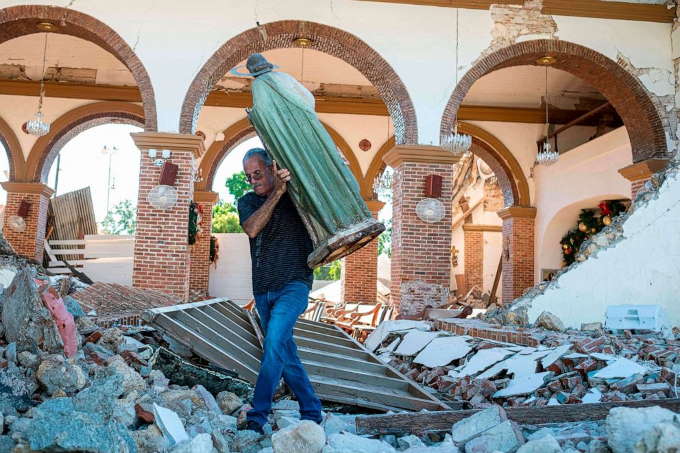 PHOTO: A man carries a St. Jude statue from the Inmaculada Concepcion church ruins that was built in 1841 and collapsed after an  earthquake hit the island in Guayanilla, Puerto Rico on Jan. 7, 2020.