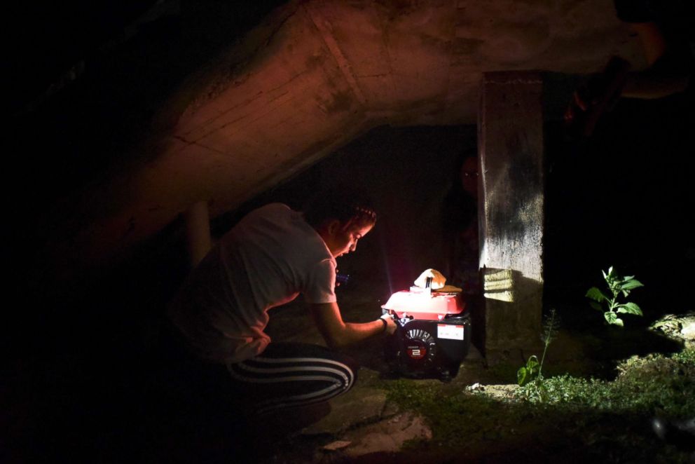 PHOTO: Resident Karina Santiago Gonzalez works on a small power plant in Morovis, Puerto Rico, Dec. 21, 2017.