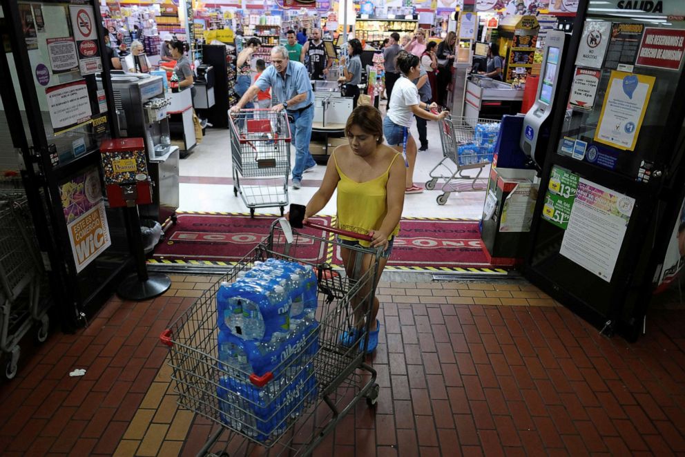 PHOTO: A woman purchases bottled water from a local grocery store as Tropical Storm Dorian approaches in Cabo Rojo, Puerto Rico, Aug. 26, 2019.