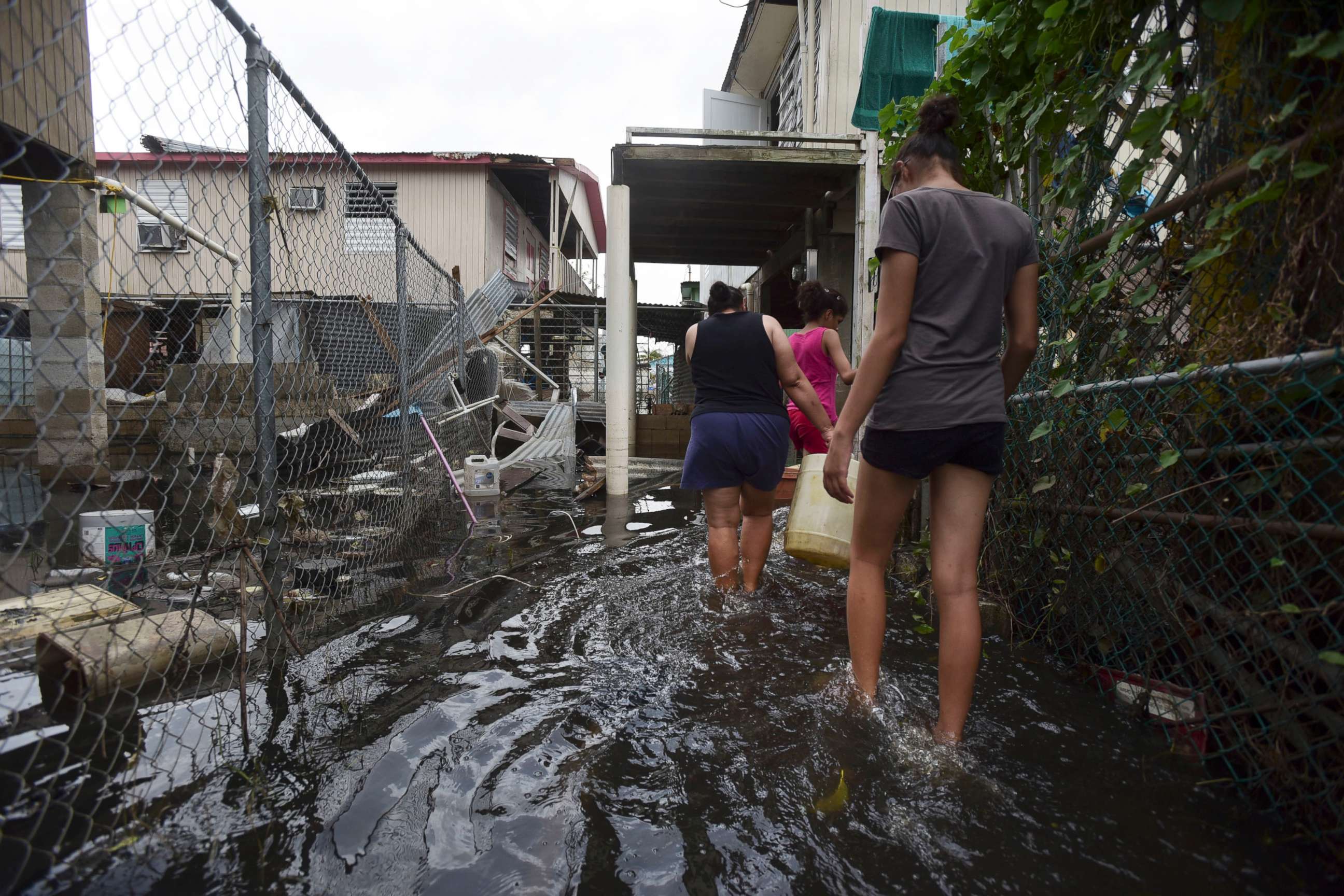 PHOTO: Residents wade through a flooded area in the aftermath of Hurricane Maria, in Catano, Puerto Rico, Sept. 27, 2017. 
