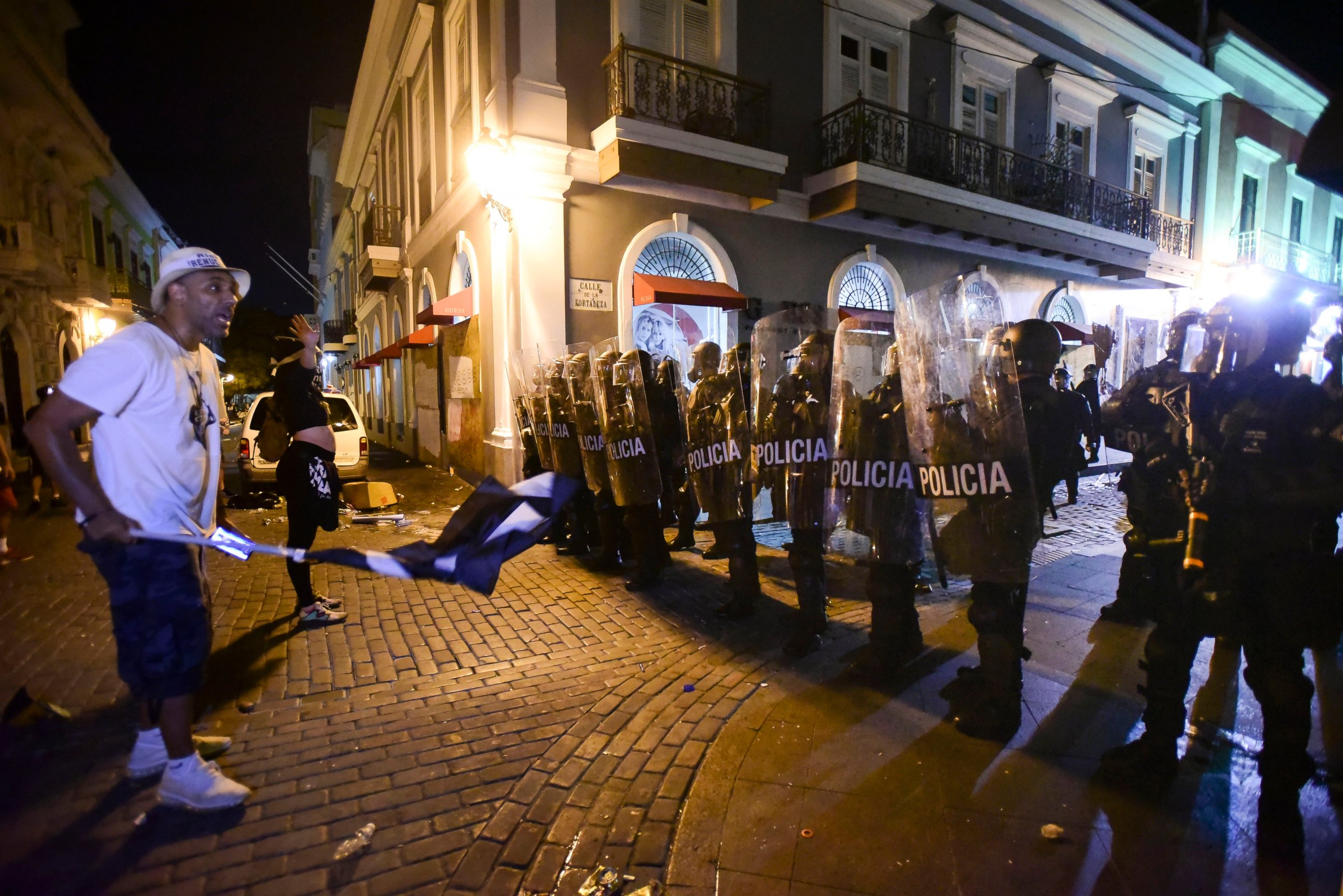 PHOTO: Demonstrators stand in front of riot control units during clashes in San Juan, Puerto Rico, Monday, July 22, 2019. Protesters are demanding Gov. Ricardo Rossello step down following the leak of an offensive, obscenity-laden online chat.