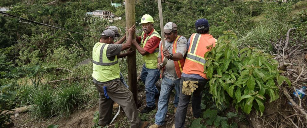 PHOTO: Public Works Sub-Director Ramon Mendez, wearing hard hat, directs locals who are municipal workers, as they install a power pole in an effort to return electricity to a home, in Coamo, Puerto Rico, Jan. 31, 2018.