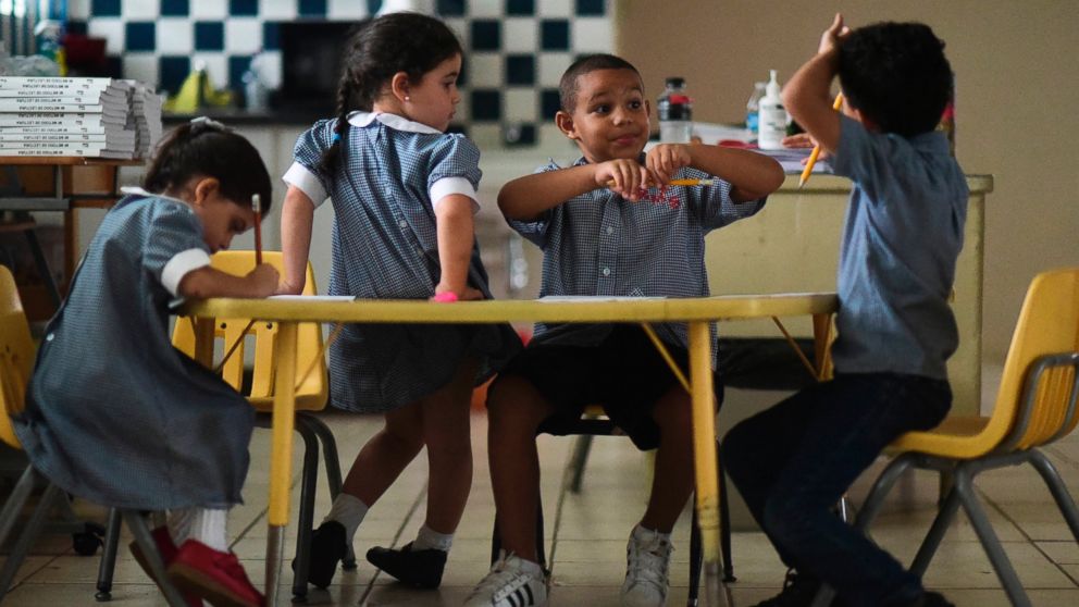 In this Oct. 13, 2017 file photo, children discuss their thoughts about Hurricane Maria at Ramon Marin Sola Elementary School in Guaynabo, Puerto Rico.