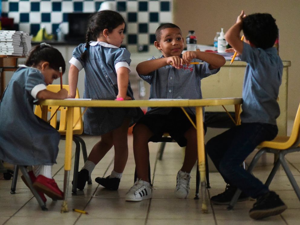 In this Oct. 13, 2017 file photo, children discuss their thoughts about Hurricane Maria at Ramon Marin Sola Elementary School in Guaynabo, Puerto Rico.