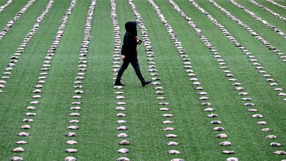 PHOTO: A woman walks between soccer-like sandbags installed on the pitch of the stadium in Herne, western Germany, November 20, 2022, during a protest to commemorate those who died building the World Cup stadiums in Qatar.