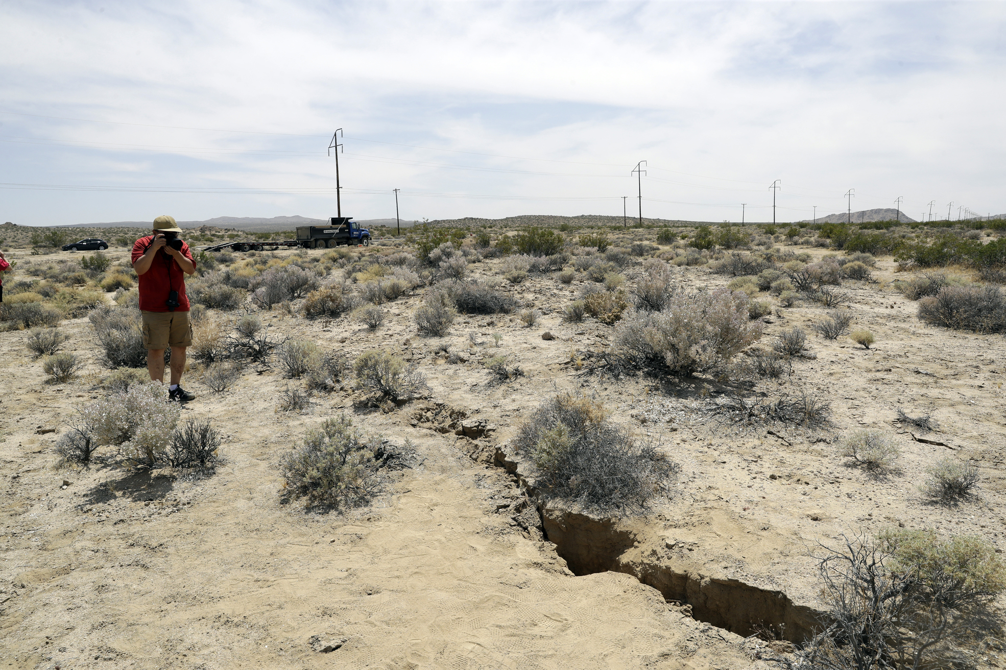 PHOTO:A visitor takes a photo of a crack on the ground following recent earthquakes, July 7, 2019, outside of Ridgecrest, Calif.