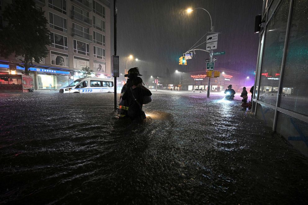 PHOTO: In this Sept. 1, 2021, file photo, members of the FDNY wade through waist high water caused by flash flooding brought by the remnants of hurricane Ida, in the New York City borough of Queens, N.Y.
