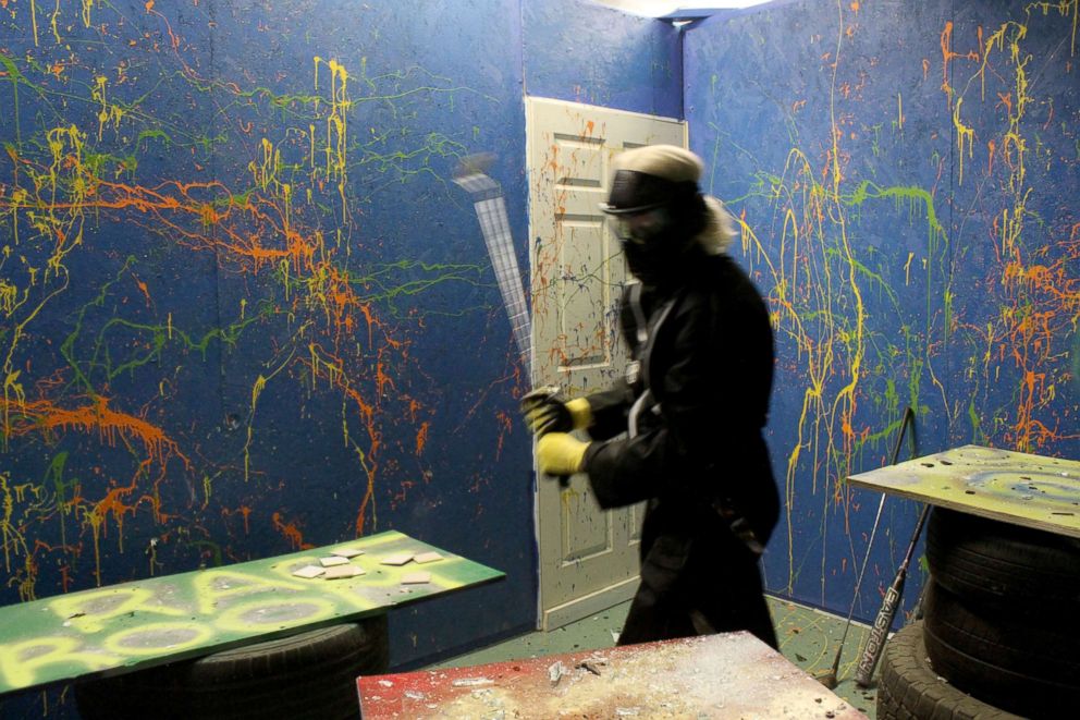 PHOTO: Participants take part in a rage room to release tension and stress.