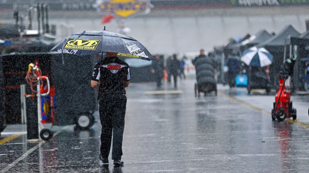 A man walks through the pit area as rain falls before a NASCAR Cup Series auto race, Saturday, Aug. 18, 2018, in Bristol, Tenn.