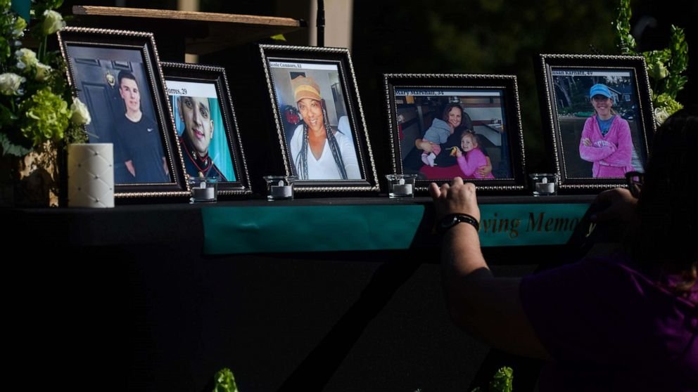 Photo: People set up a memorial table with pictures of shooting victims for a vigil in the Hedingham neighborhood on Oct. 15, 2022, in Raleigh, NC.