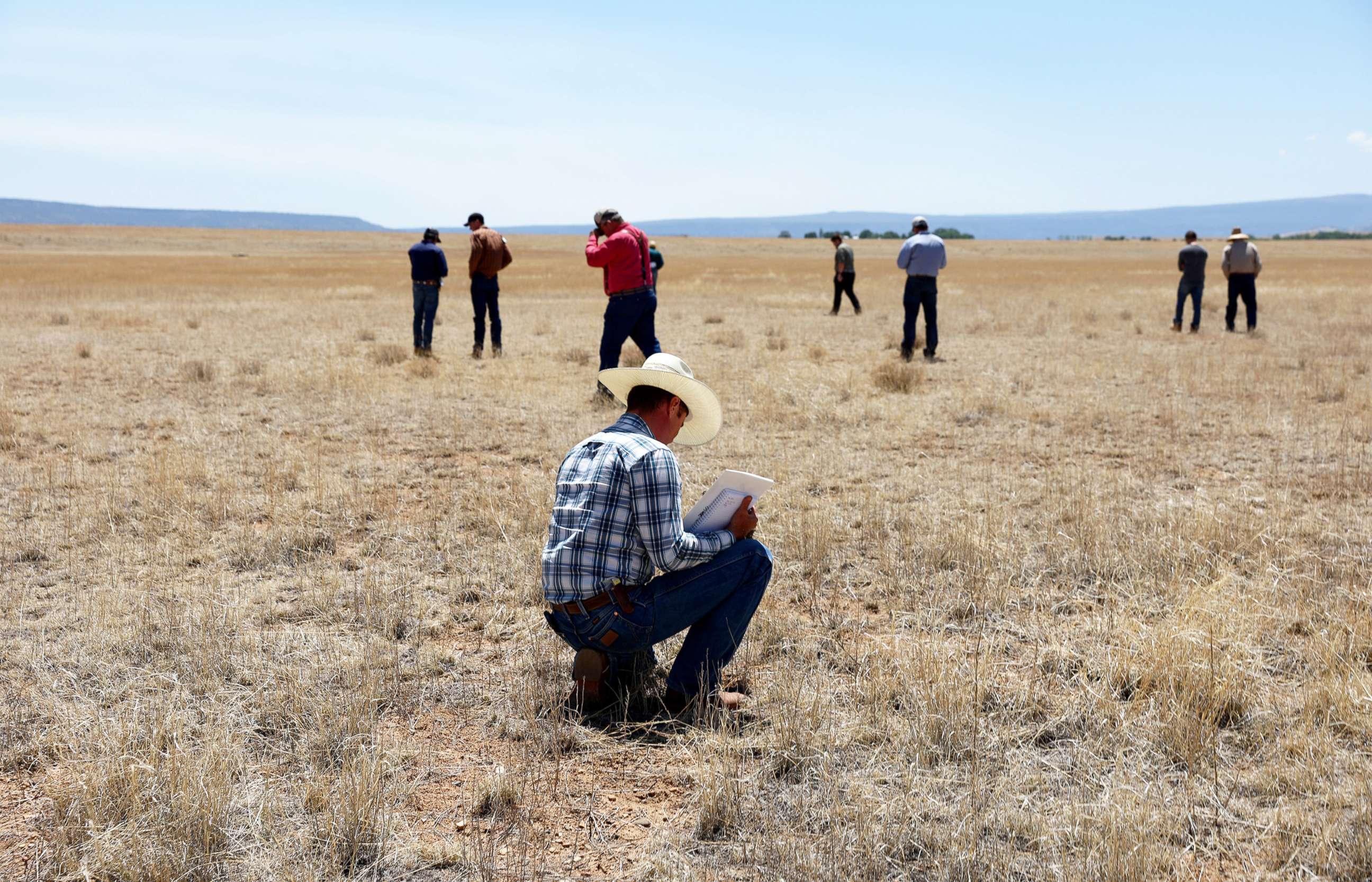 PHOTO: Ranchers and other participants observe drought stressed pasture as they take part in the Soil Health Academy, which teaches regenerative agriculture techniques, on May 31, 2022, in Cimarron, New Mexico.
