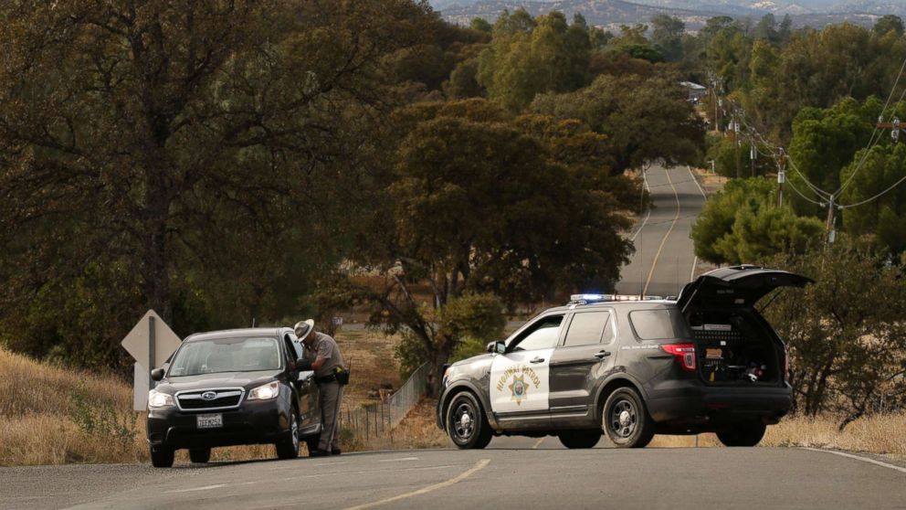 PHOTO: A Highway Patrol officer speaks to a woman while blocking off a road to traffic after a shooting on Nov. 14, 2017, in Rancho Tehama, Calif.