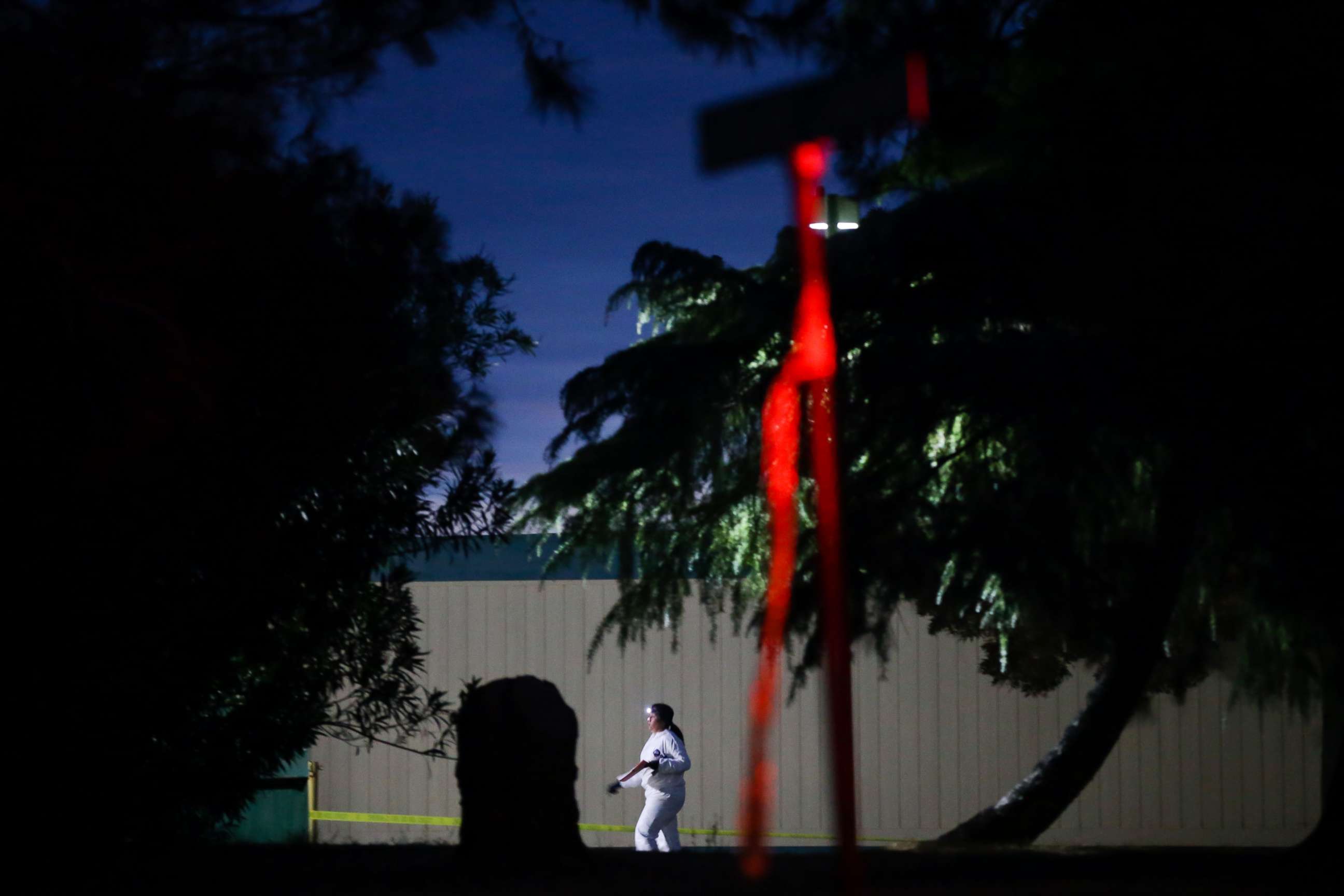 PHOTO: A woman wearing a white protective suit is seen on the Rancho Tehama Elementary school grounds after a shooting on Nov. 14, 2017, in Rancho Tehama, Calif.