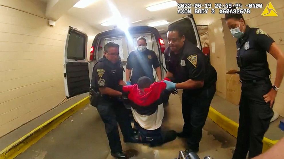 PHOTO: In this image taken from police body camera video provided by New Haven Police, Richard "Randy" Cox, center, is pulled from the back of a police van and placed in a wheelchair after being detained, June 19, 2022, in New Haven, Conn.
