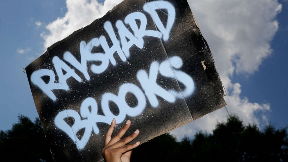 PHOTO: A protester holds up a sign on Saturday, June 13, 2020, near the Wendy's restaurant where Rayshard Brooks was shot and killed by police Friday evening following a struggle in the restaurant's drive-thru line in Atlanta.