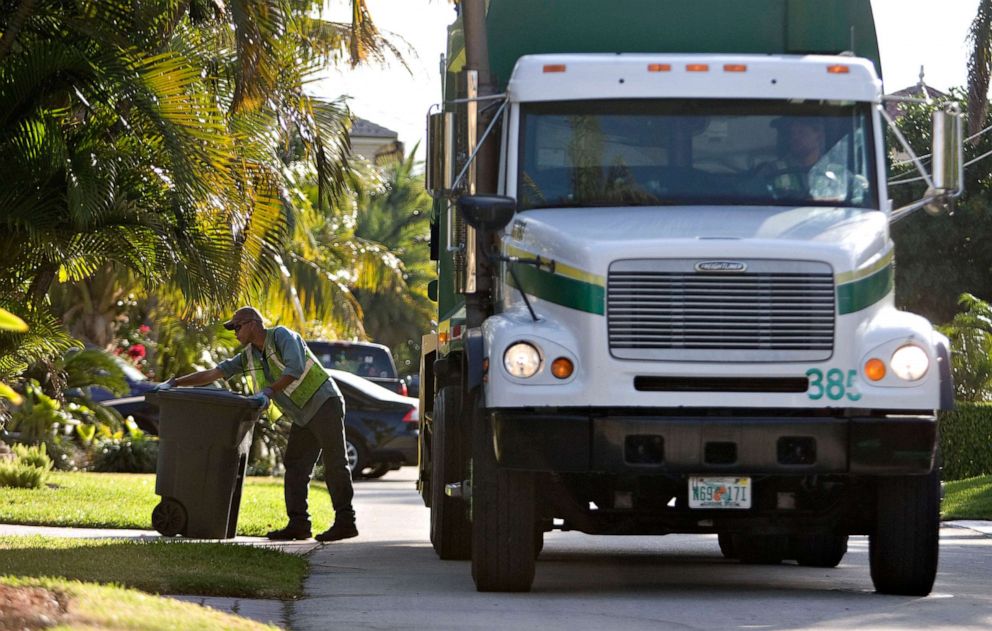 PHOTO: Anthony Gunari places a garbage can back on the curb after emptying it into a Waste Management truck as it collects residential trash in Lighthouse Point, Florida, March 5, 2009.