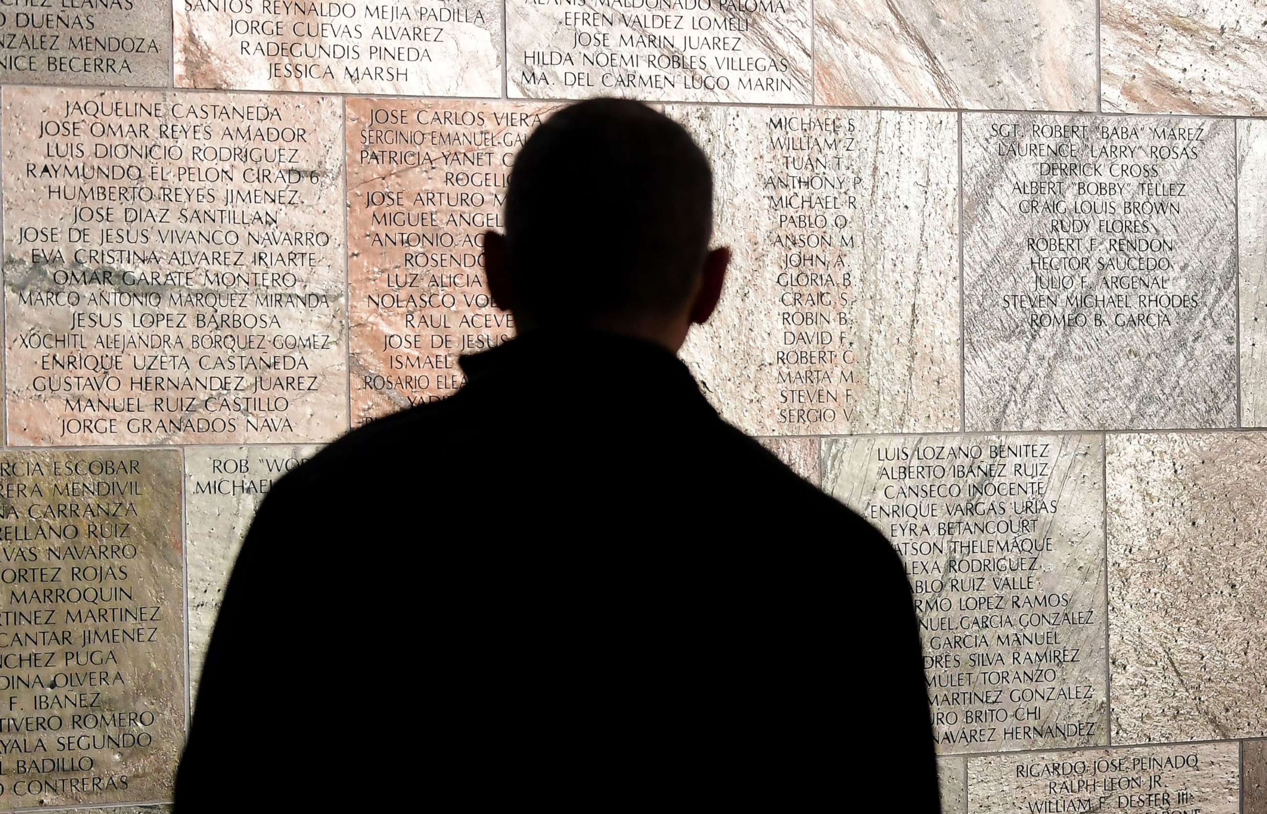 PHOTO: A man reads names on the Wall Las Memorias as people attend the rededication ceremony for the AIDS Monument in Lincoln Parkon on World AIDS Day, Dec. 1, 2021 in Los Angeles.