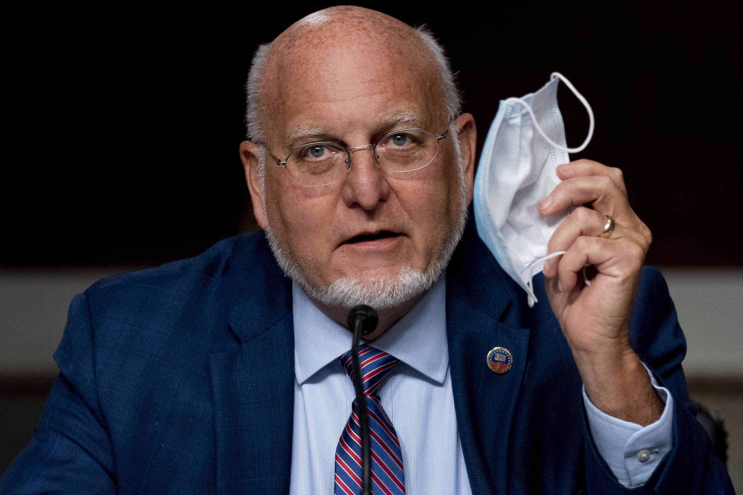 PHOTO: Centers for Disease Control and Prevention Director Dr. Robert Redfield holds up his mask as he speaks at a Senate Appropriations subcommittee hearing on Capitol Hill, Sept. 16, 2020, in Washington.