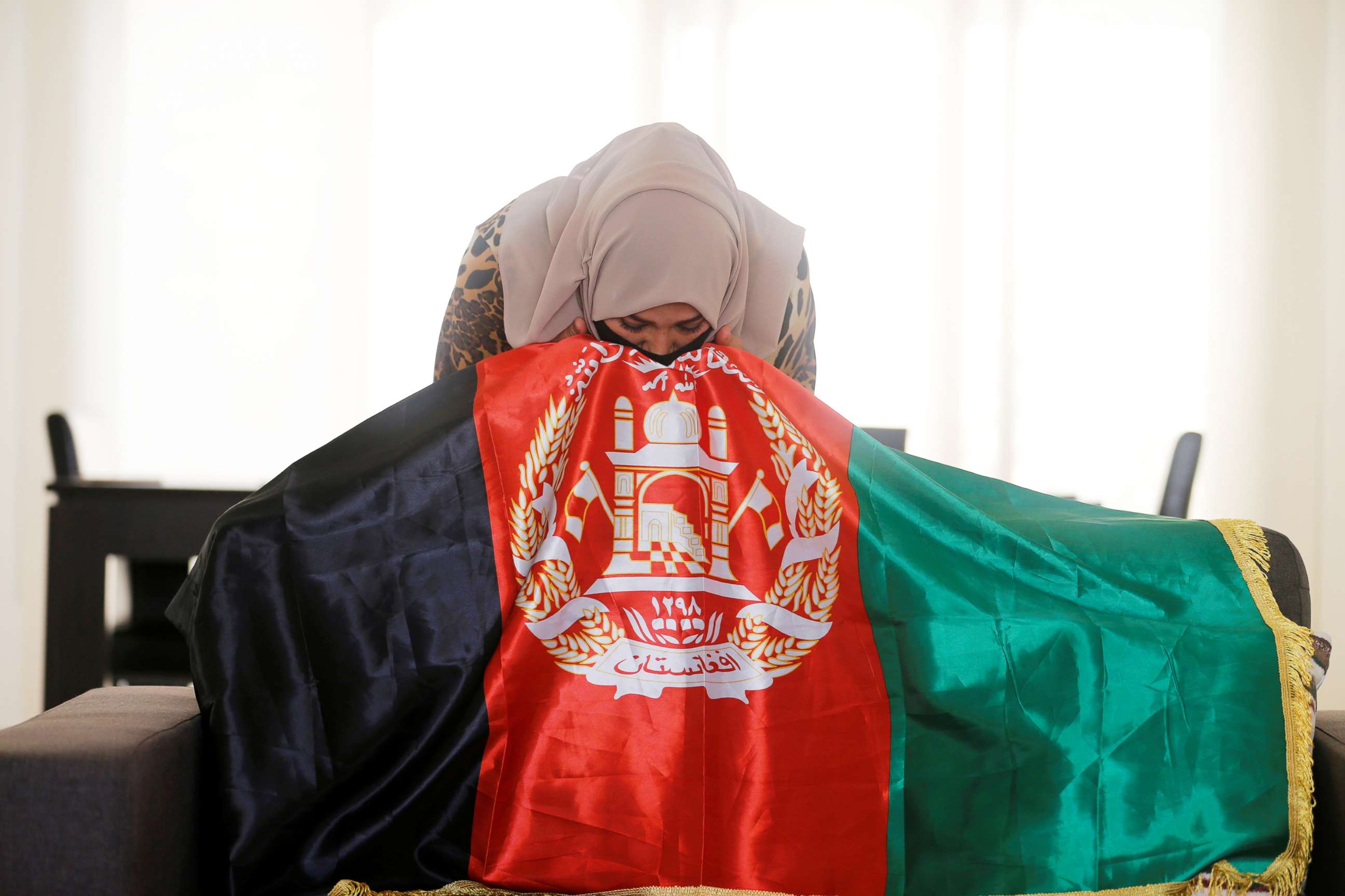 PHOTO: Mariam Sayar, an Afghani evacuee, kisses her national flag at a temporary residence compound in Doha, Qatar, Aug. 27, 2021.