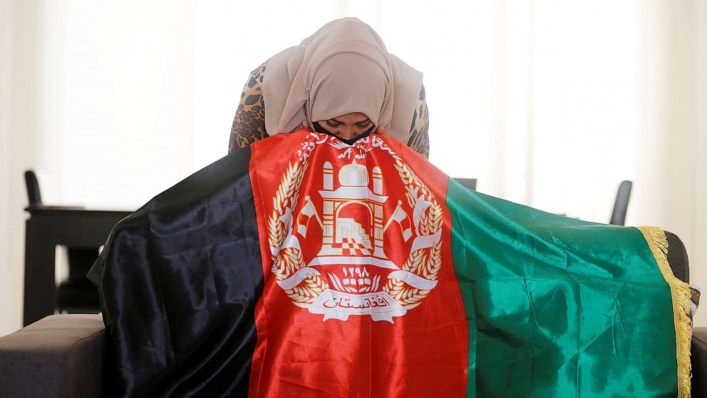 PHOTO: Mariam Sayar, an Afghani evacuee, kisses her national flag at a temporary residence compound in Doha, Qatar, Aug. 27, 2021.
