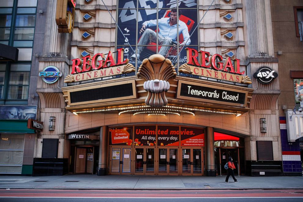 PHOTO: In this March 21, 2020 file photo, a pedestrian wearing a protective face mask due to COVID-19 concerns walks by a shuttered movie theater in New York. 