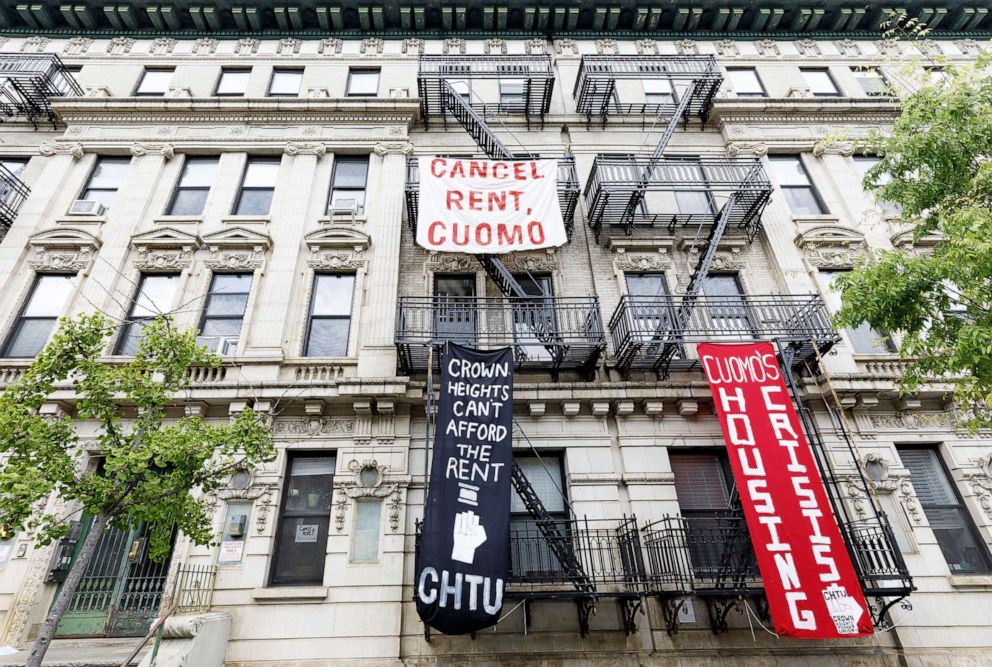 PHOTO: Signs hang on an apartment building calling on New York Governor Andrew Cuomo to cancel the rent as part of an organized rent strike in conjunction with May Day in Brooklyn, New York, May 1, 2020.
