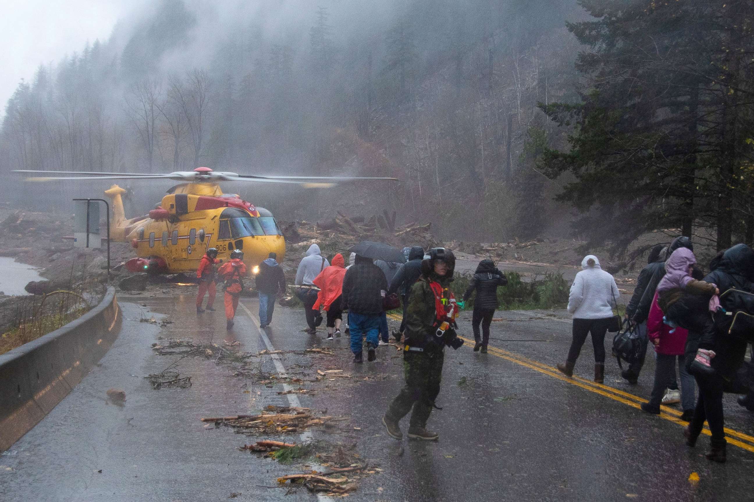 PHOTO: Crew members from Royal Canadian Air Force 442 Squadron lead some of over 300 motorists stranded by mudslides towards a CH-149 Cormorant helicopter for their evacuation, in Agassiz, British Columbia, Canada, Nov. 15, 2021. 