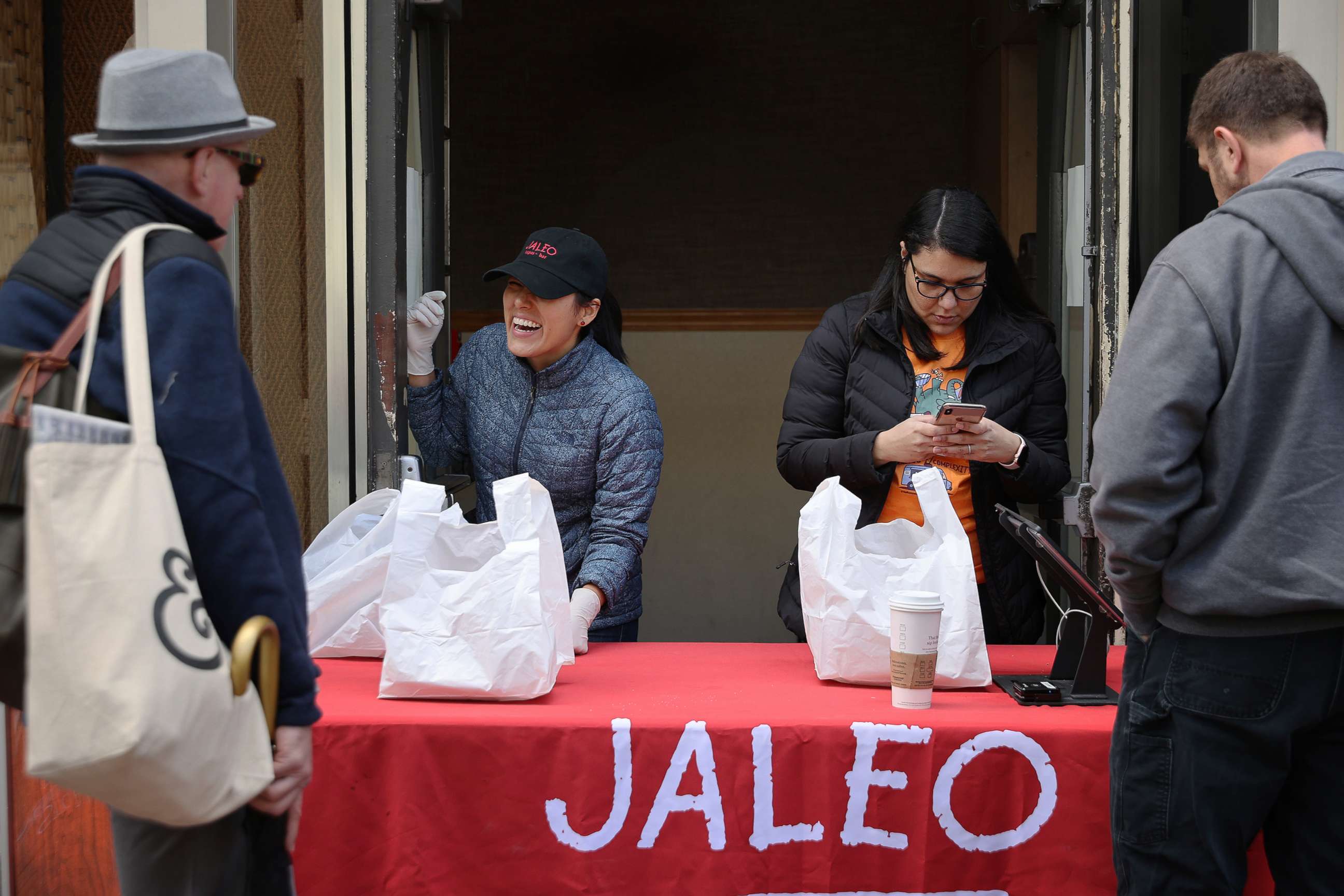 PHOTO: People purchase carry-out lunches out of the back door of Jaleo restaurant in response to the novel coronavirus, March 17, 2020, in Washington, D.C.