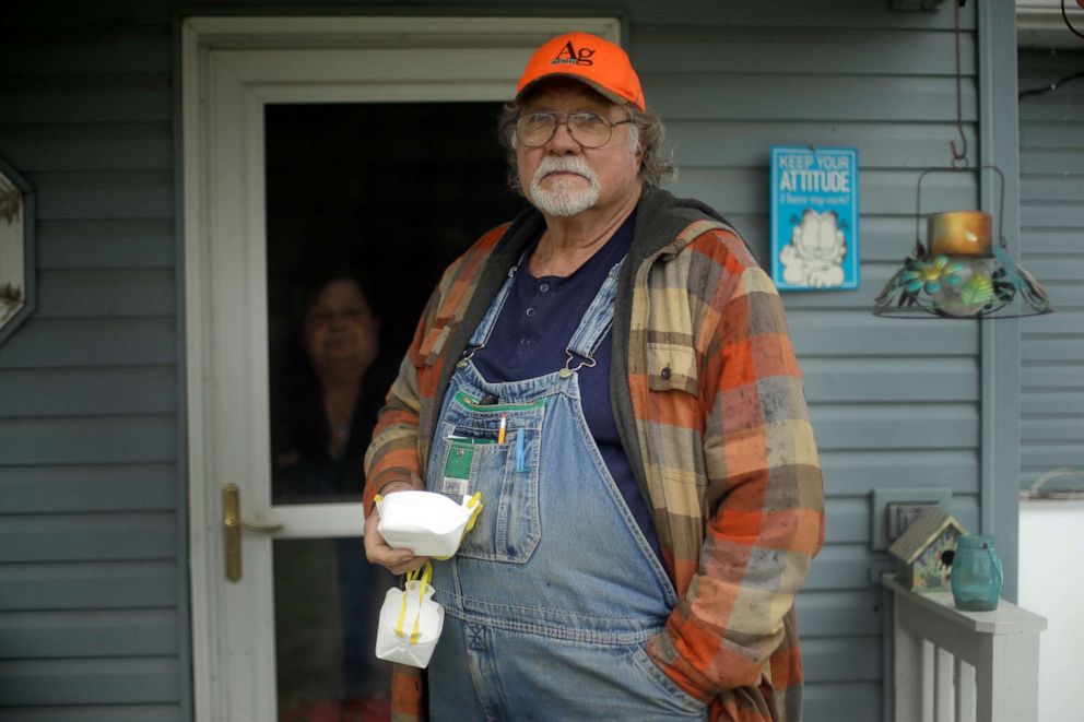 PHOTO: Dennis Ruhnke holds two of his remaining N-95 masks as he stands with his wife, Sharon, at their home near Troy, Kansas, on April 24, 2020.
