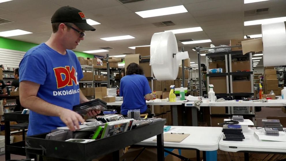 PHOTO: Employees at DK Oldies sift through their inventory of retro gaming systems and games.