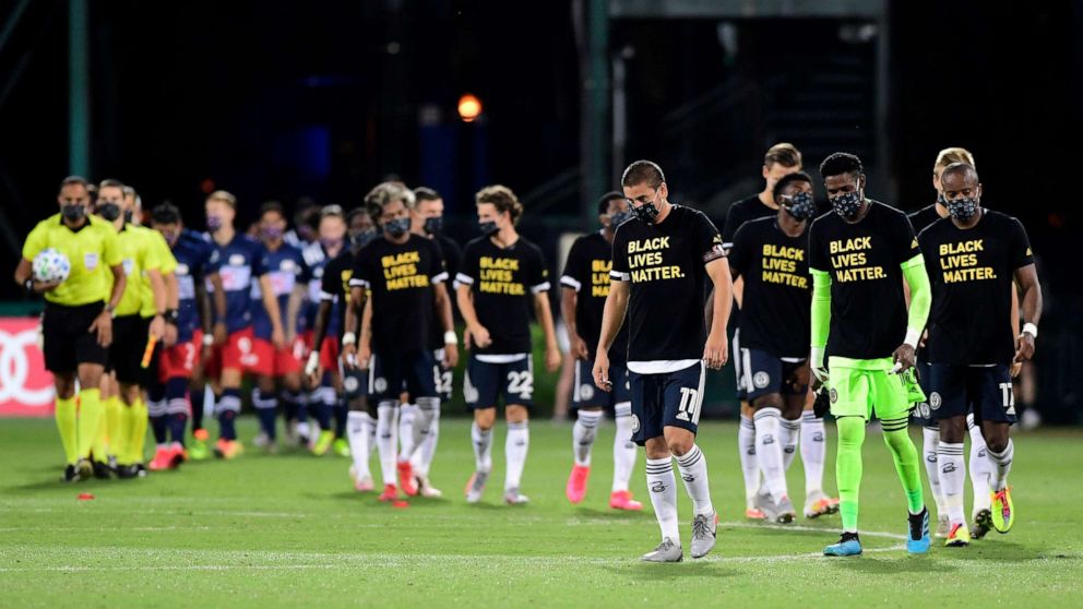 PHOTO: Philadelphia Union and New England Revolution players walk on the pitch prior to their game during the knockout round of the MLS is Back Tournament at ESPN Wide World of Sports Complex, July 25, 2020, in Reunion, Florida.