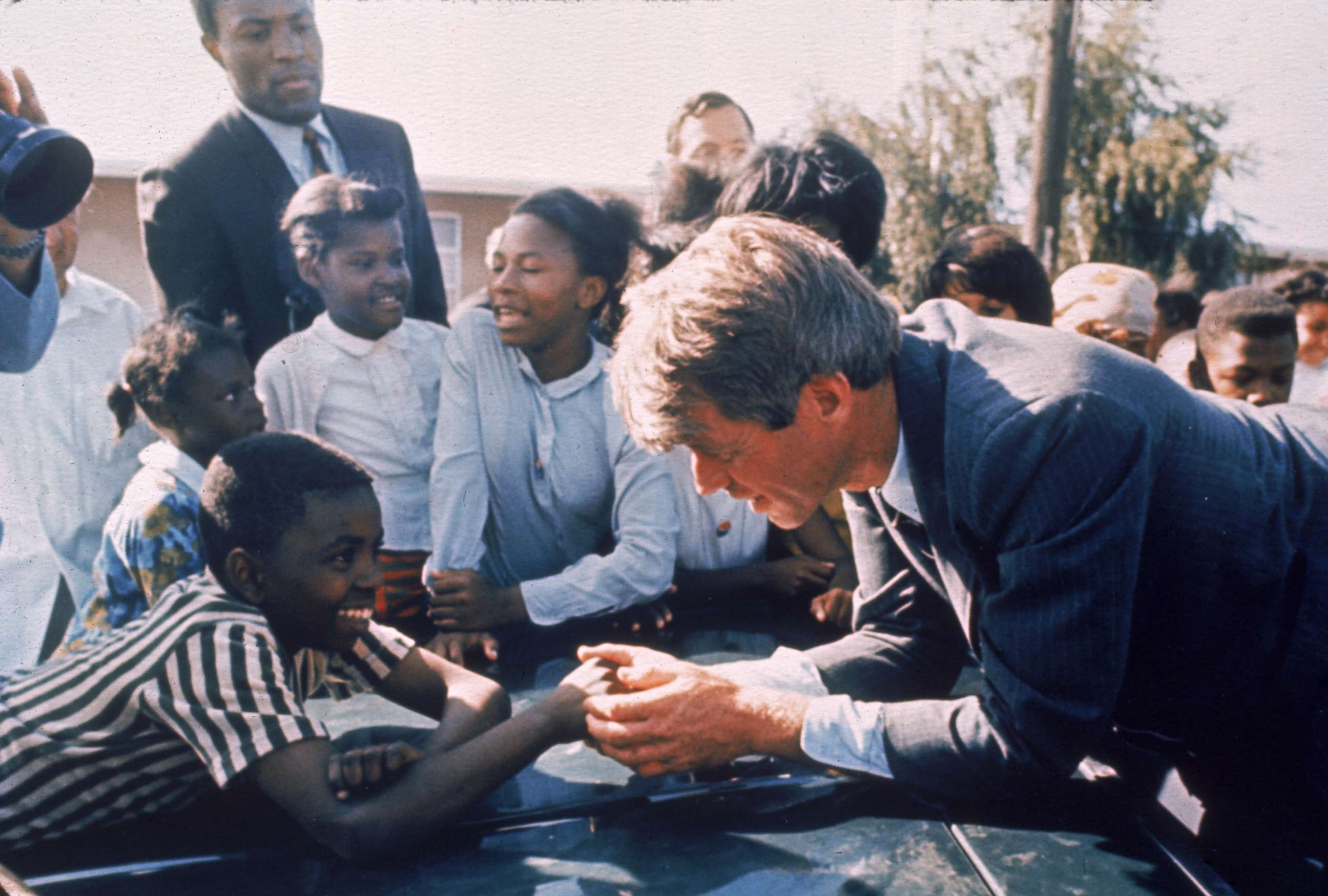 PHOTO: Presidential contender Bobby Kennedy stops during campaigning to shake hands with delighted young boy, April 1968.