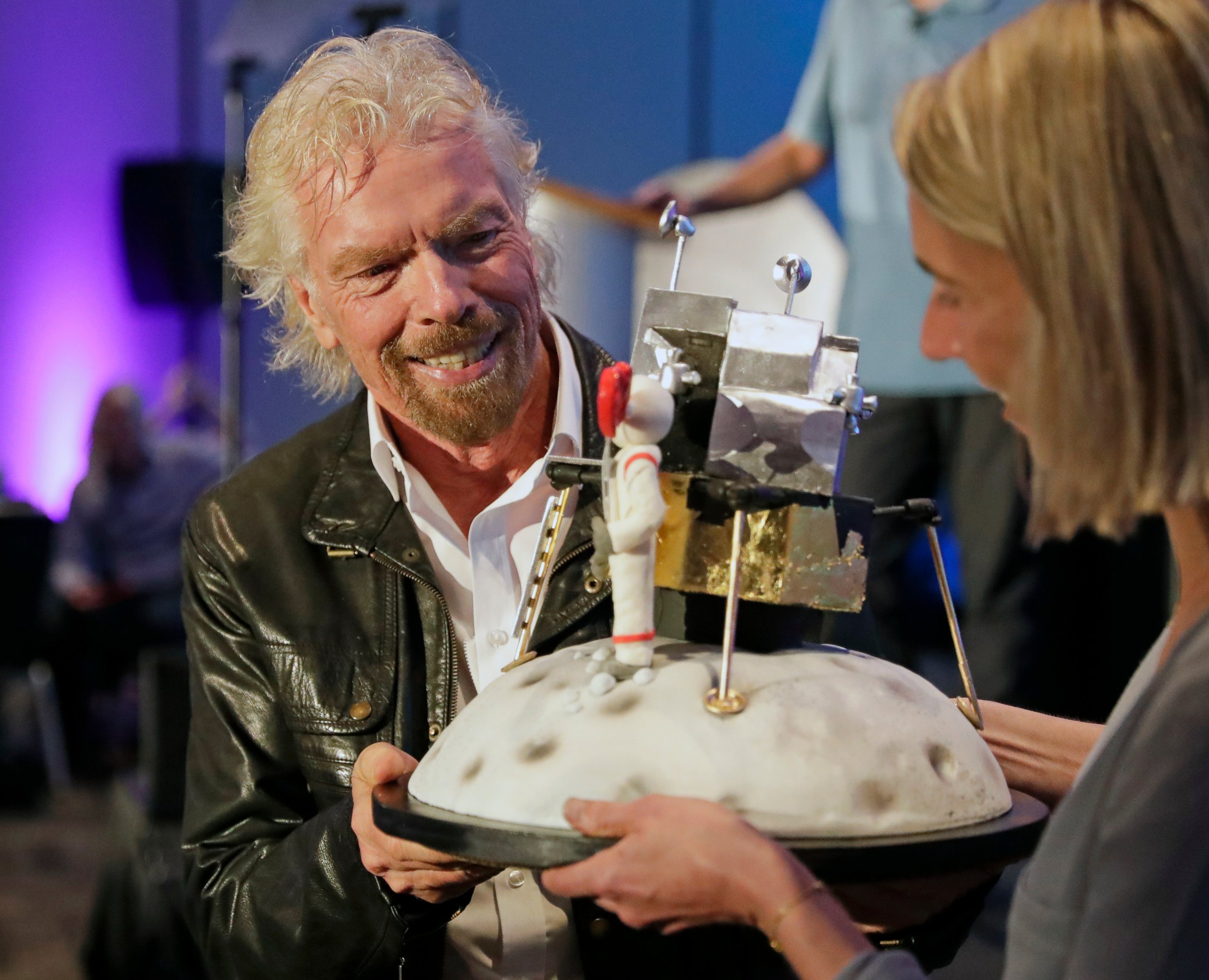 PHOTO: Richard Branson is presented with a space-themed cake during a lunch attended by Virgin Galactic ticket holders, to mark his 69th birthday and in recognition of the Apollo 11 moon landing anniversary Thursday, July 18, 2019, in Cape Canaveral, Fla.