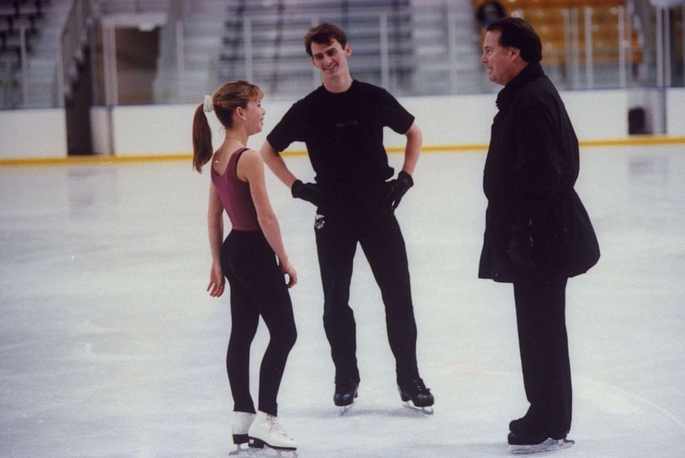 PHOTO: In this file photo from 1997, figure skating champion Todd Eldredge (C) chats with figure skating champion Tara Lipinski &amp; his coach Richard Callaghan during a break in practice session at the Detroit Skating Club.