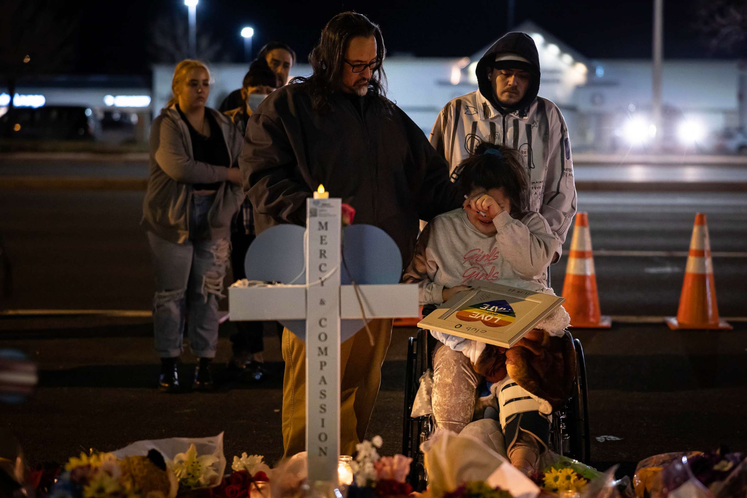 PHOTO: Richard Fierro consoles his daughter, Kassandra, as she signs a plaque to her slain boyfriend at a memorial outside of Club Q, Nov. 22, 2022 in Colorado Springs, Colorado. 