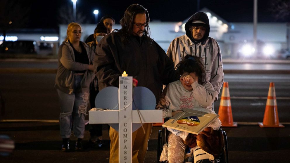 PHOTO: Richard Fierro consoles his daughter, Kassandra, as she signs a plaque to her slain boyfriend at a memorial outside of Club Q, Nov. 22, 2022 in Colorado Springs, Colorado. 