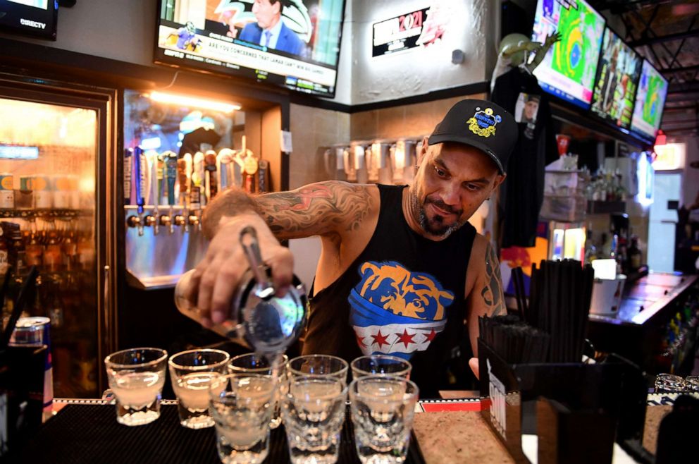 PHOTO: Rob Koski, a bartender at Salty Jim's Island Bar & Grill, pours a round of Lemon Drops for customers having a hurricane party at the bar in Sarasota, Fla., Sept. 28, 2022.