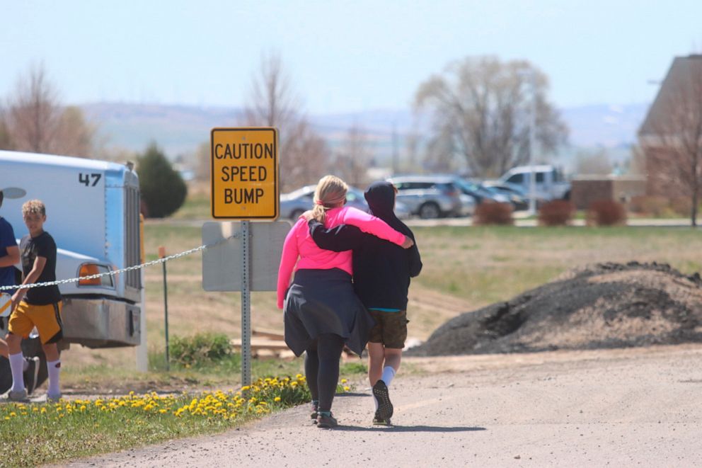 PHOTO: Two people walk together near the scene of a shooting at an eastern Idaho middle school Thursday, May 6, 2021, in Rigby, Idaho.
