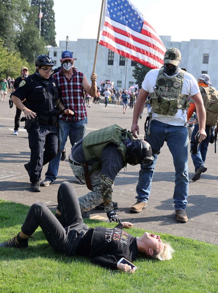 PHOTO: A Black Lives Matter activist lies on the ground as he is hit by supporters of President Donald Trump during a scuffle between the two groups outside the Oregon State Capitol building in Salem, Oregon, Sept. 7, 2020.