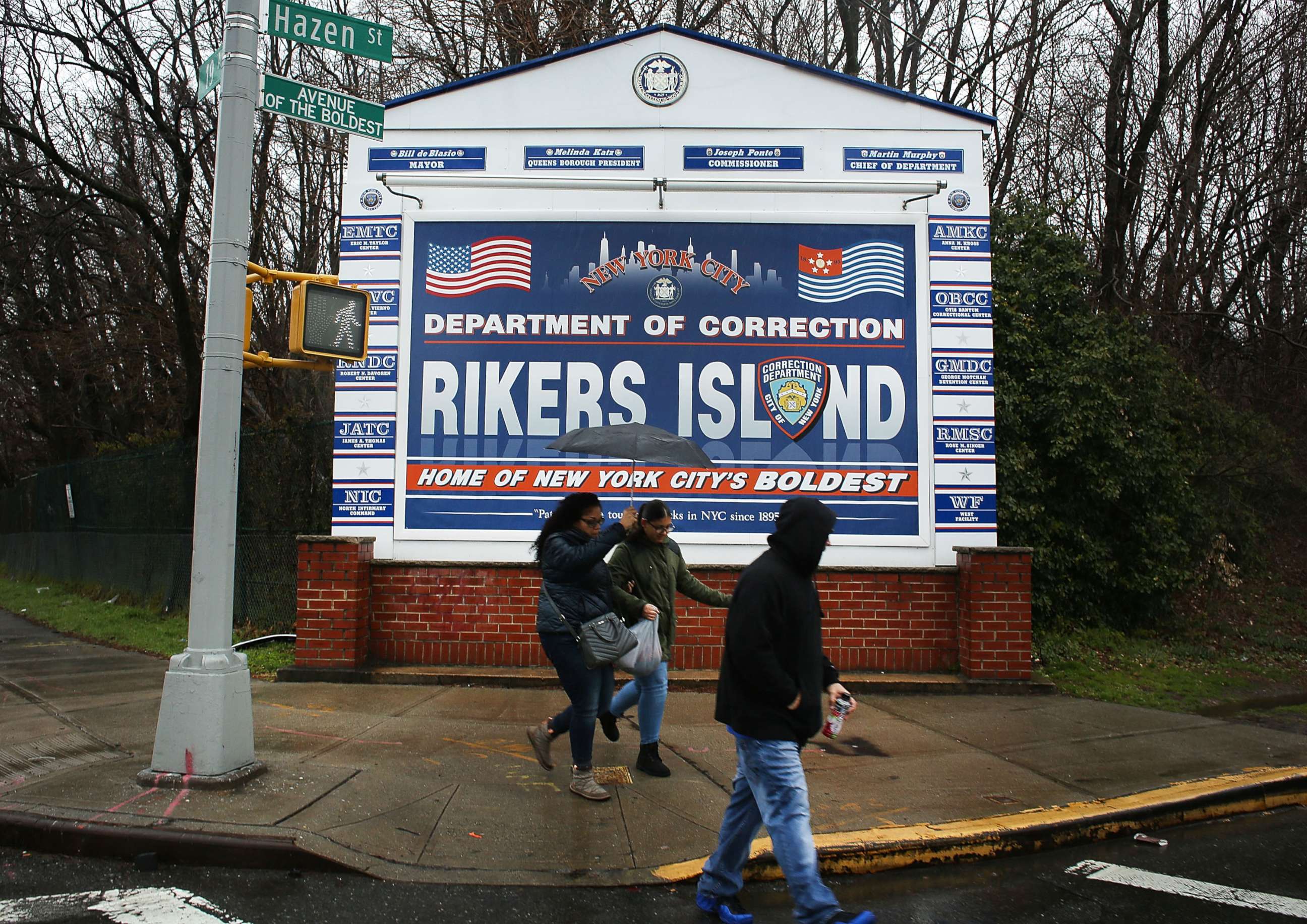 PHOTO: People walk by a sign at the entrance to Rikers Island, March 31, 2017, in New York.