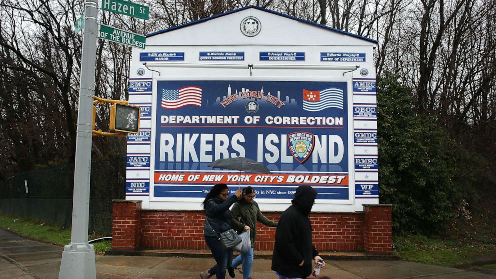 PHOTO: People walk by a sign at the entrance to Rikers Island, March 31, 2017, in New York.