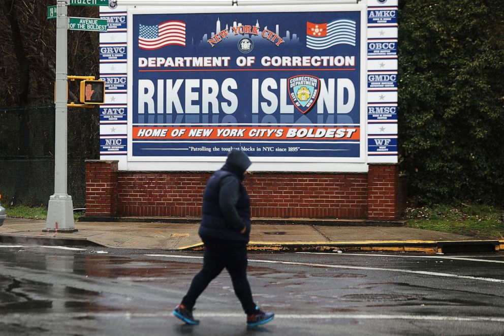 PHOTO: A person walks by a sign at the entrance to Rikers Island, March 31, 2017, in New York.