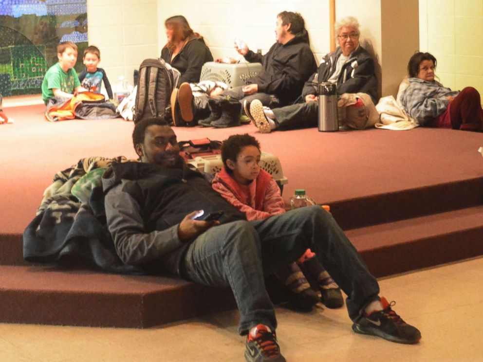 PHOTO: Abdulai Salam and his daughter Mina wait for the all-clear at Homer High School during a tsunami alert for Homer, Alaska at about 2:30 a.m., Jan. 23, 2018.