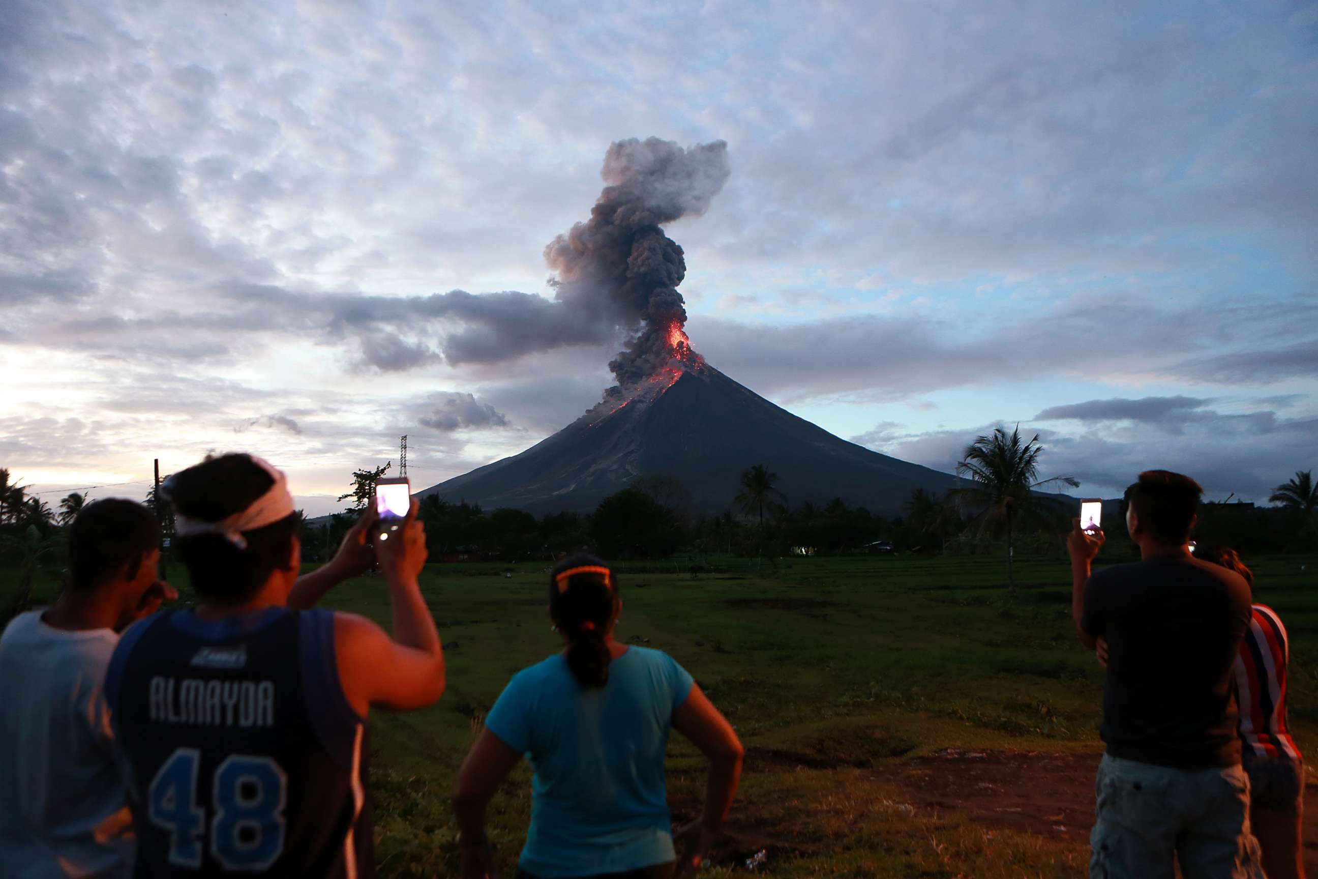 PHOTO: Residents watch the glowing lava flowing from the crater of the Mount Mayon volcano as it erupts in Albay Province, the Philippines, Jan. 23, 2018.