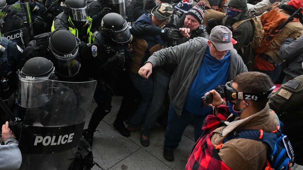 PHOTO: Riot police push back a crowd of supporters of US President Donald Trump after they stormed the Capitol building on January 6, 2021 in Washington, DC. 
