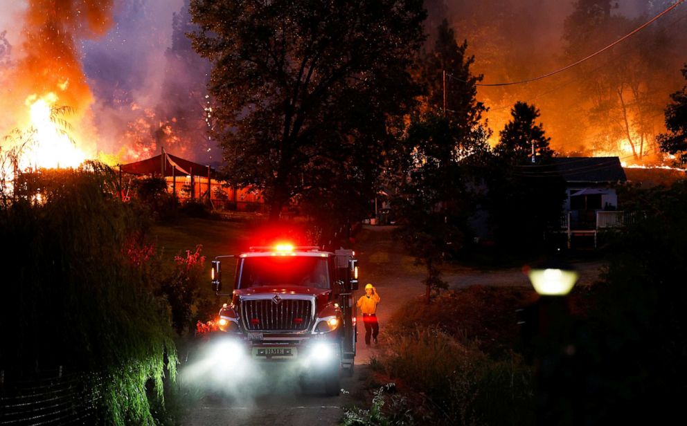 PHOTO: A firefighter guides a firetruck down a driveway to protect homes threatened by the flames at the River Fire, a wildfire near the Placer County town of Grass Valley, Calif., Aug. 4, 2021.
